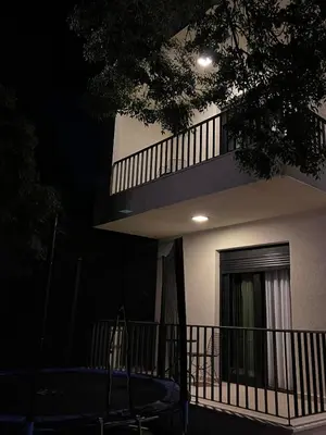 a building at night with a table in front of it at Apartments E&S in Ulcinj