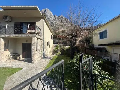 a house with a balcony with a mountain in the background at Apartments Samardzic in Kotor