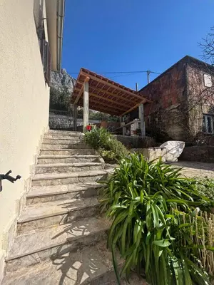 a set of stairs leading to a house with a wooden awning at Apartments Samardzic in Kotor