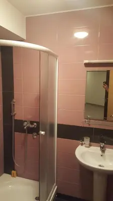 a bathroom with a shower and a sink and a mirror at Apartment For a Day in Podgorica
