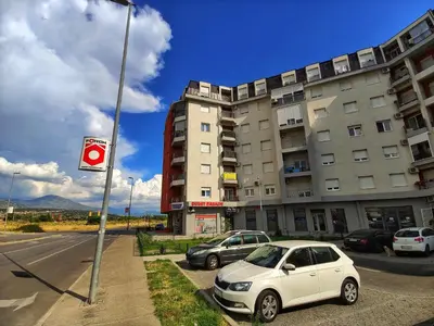 a white car parked in front of a building at Apartment For a Day in Podgorica