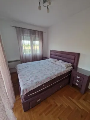 a bedroom with a large bed and a window at Apartment For a Day in Podgorica