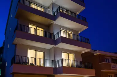 a tall building with balconies at night at Hotel Bono in Budva