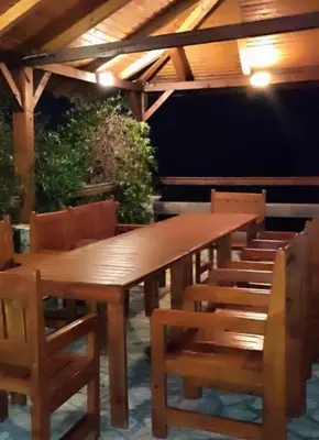 a wooden table and chairs with a wooden roof at Lilo in Dobra Voda