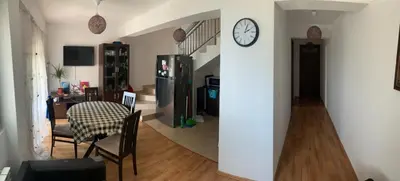 a living room with a table and a clock on a wall at Lilo in Dobra Voda