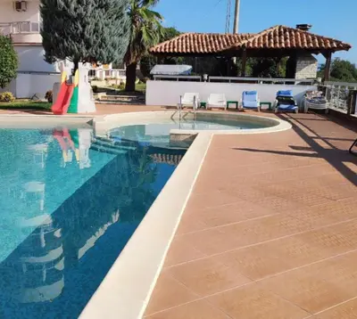 a swimming pool next to a resort with a gazebo at Lilo in Dobra Voda