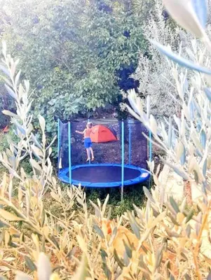 a young boy is playing on a trampoline at Apartments Stella in Virpazar