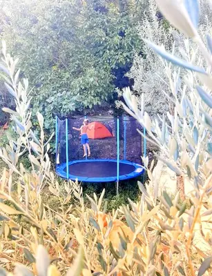 a boy on a trampoline in a backyard at Auto camp Radoman in Virpazar