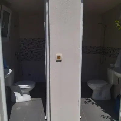 a bathroom with two toilets and a sink at Auto camp Radoman in Virpazar