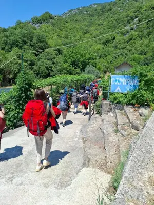 a group of people walking up a mountain at Auto camp Radoman in Virpazar