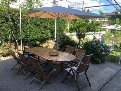 a wooden table and chairs with an umbrella at Lavender Vacation Home, Bar in Bar