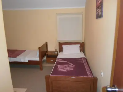 a small bedroom with two beds and a window at Vila Patria in Podgorica