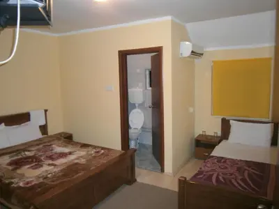 a hotel room with two beds and a bathroom at Vila Patria in Podgorica