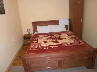 a bedroom with a large bed with a wooden frame at Vila Patria in Podgorica