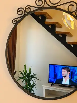 a mirror in a room with a tv and a staircase at Apart 31 in Cetinje