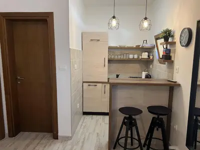 a kitchen with two stools and a counter with a sink at Apart 31 in Cetinje