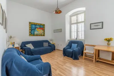 a living room with two blue chairs and a table at CENTRAL CATHEDRAL APARTMENT in Kotor