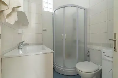a white bathroom with a shower and a toilet at CENTRAL CATHEDRAL APARTMENT in Kotor