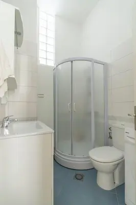 a white bathroom with a shower and a toilet at CENTRAL CATHEDRAL APARTMENT in Kotor