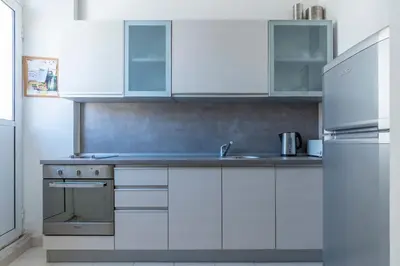 a kitchen with white cabinets and a stainless steel refrigerator at CENTRAL CATHEDRAL APARTMENT in Kotor