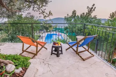 two chairs and a table on a balcony with a pool at Villa Marco Polo in Budva