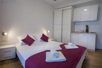 a bedroom with a large white bed with towels on it at Villa Marco Polo in Budva