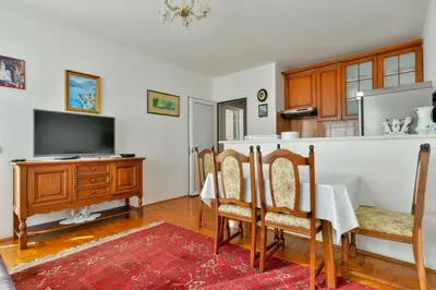 a dining room with a table and a kitchen at Apartment Ruzica in Sveti Stefan