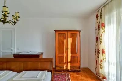 a bedroom with a bed and a wooden cabinet at Apartment Ruzica in Sveti Stefan