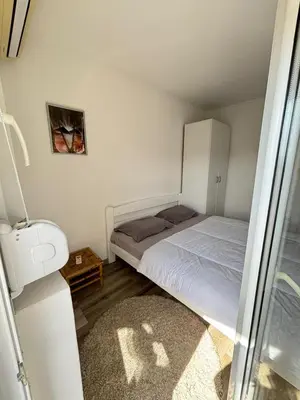 a small bedroom with a bed and a cabinet at Saša Apartments in Sutomore