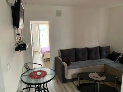 a living room with a couch and two tables at Saša Apartments in Sutomore