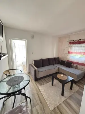 a living room with a couch and two tables at Saša Apartments in Sutomore