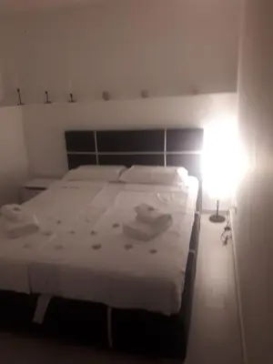 a bedroom with a white bed with a light on it at Luna apartment in Petrovac na Moru