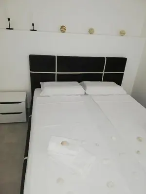 a bedroom with two beds with white sheets at Luna apartment in Petrovac na Moru