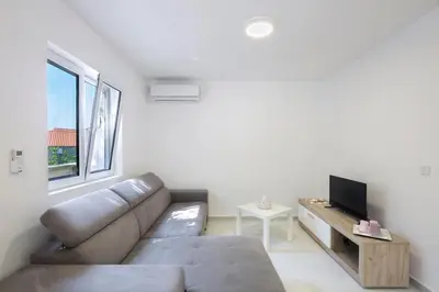 a living room with a couch and a tv at Luna apartment in Petrovac na Moru