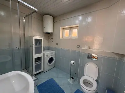 a bathroom with a toilet sink and a washing machine at Apartments Aleksić Old Town in Budva