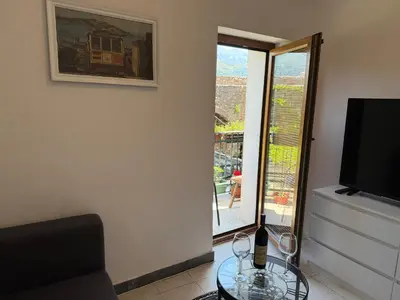 a living room with a glass table and a television at Apartments Aleksić Old Town in Budva