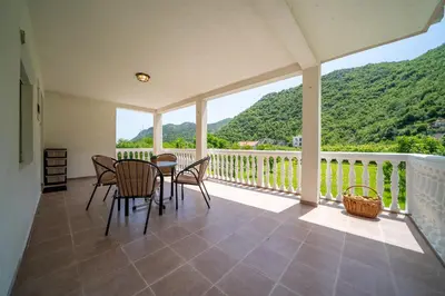a dining room with a table and chairs on a balcony at House Gorica in Bar