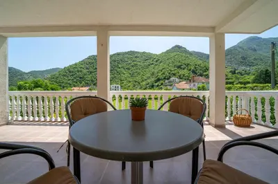 a table on a porch with a view of mountains at House Gorica in Bar