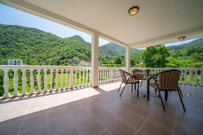 a porch with a table and chairs and mountains at House Gorica in Bar