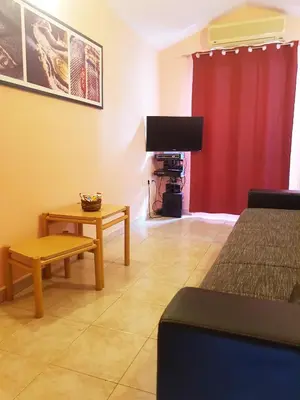 a room with a bed and a table and a red curtain at Apartment Danijela in Budva