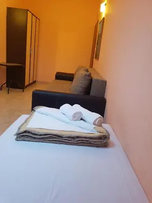 a bed with two towels on it with a couch at Apartment Danijela in Budva