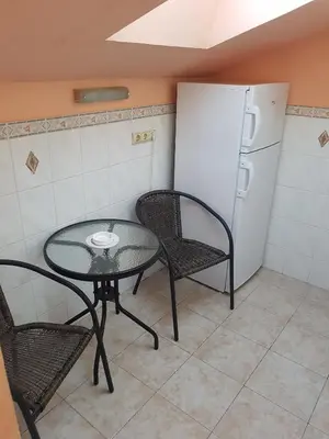 a table and chairs in a kitchen with a refrigerator at Apartment Danijela in Budva