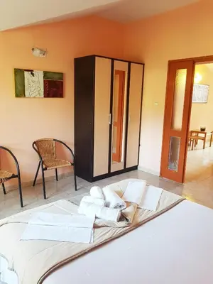 a large bed in a room with two chairs at Apartment Danijela in Budva