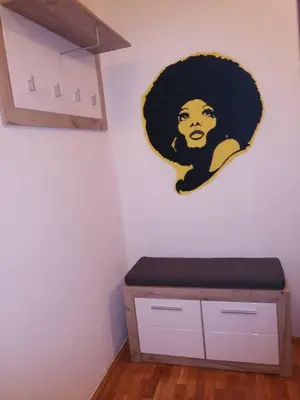 a wall with a painting of a woman on a wall at Yellow apartment, central Podgorica in Podgorica