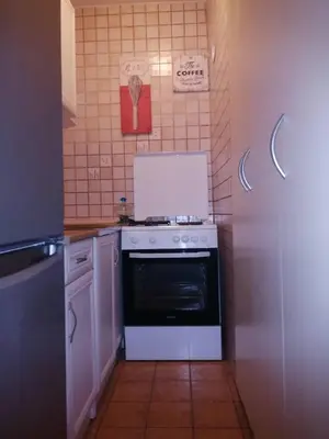 a kitchen with a white stove and a refrigerator at Yellow apartment, central Podgorica in Podgorica