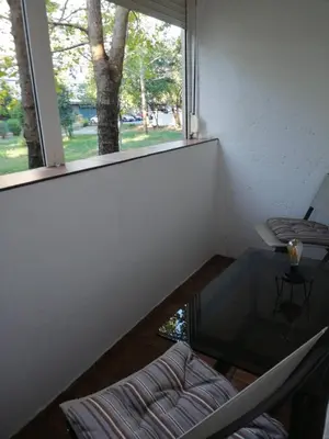 a room with a window and a couch and a table at Yellow apartment, central Podgorica in Podgorica