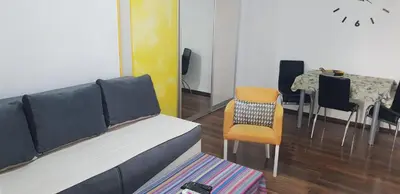 a living room with a couch and a table and chairs at Yellow apartment, central Podgorica in Podgorica