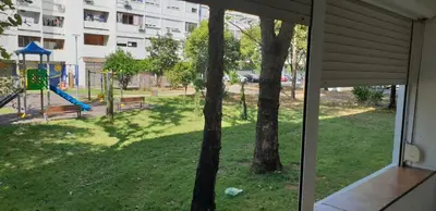 a window view of a playground with a slide at Yellow apartment, central Podgorica in Podgorica