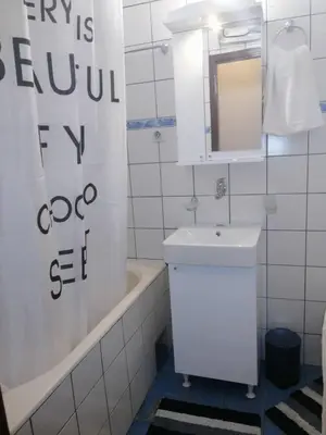 a bathroom with a sink and a tub and a mirror at Yellow apartment, central Podgorica in Podgorica