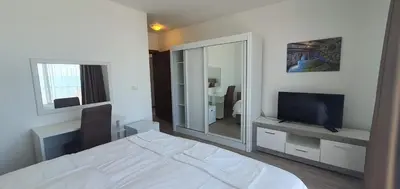a bedroom with a bed and a tv and a mirror at Hotel Svarog in Becici